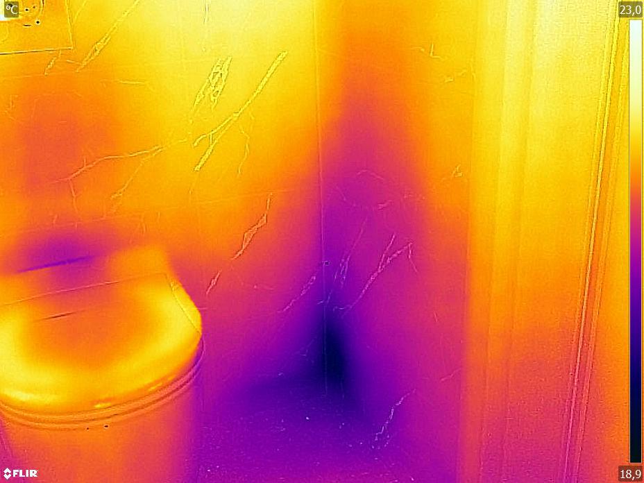 Termogram przedstawia obraz w podczerwieni. Widoczne jest zawilgocenie narożnika łazienki przy zabudowie spłuczki podtynkowej