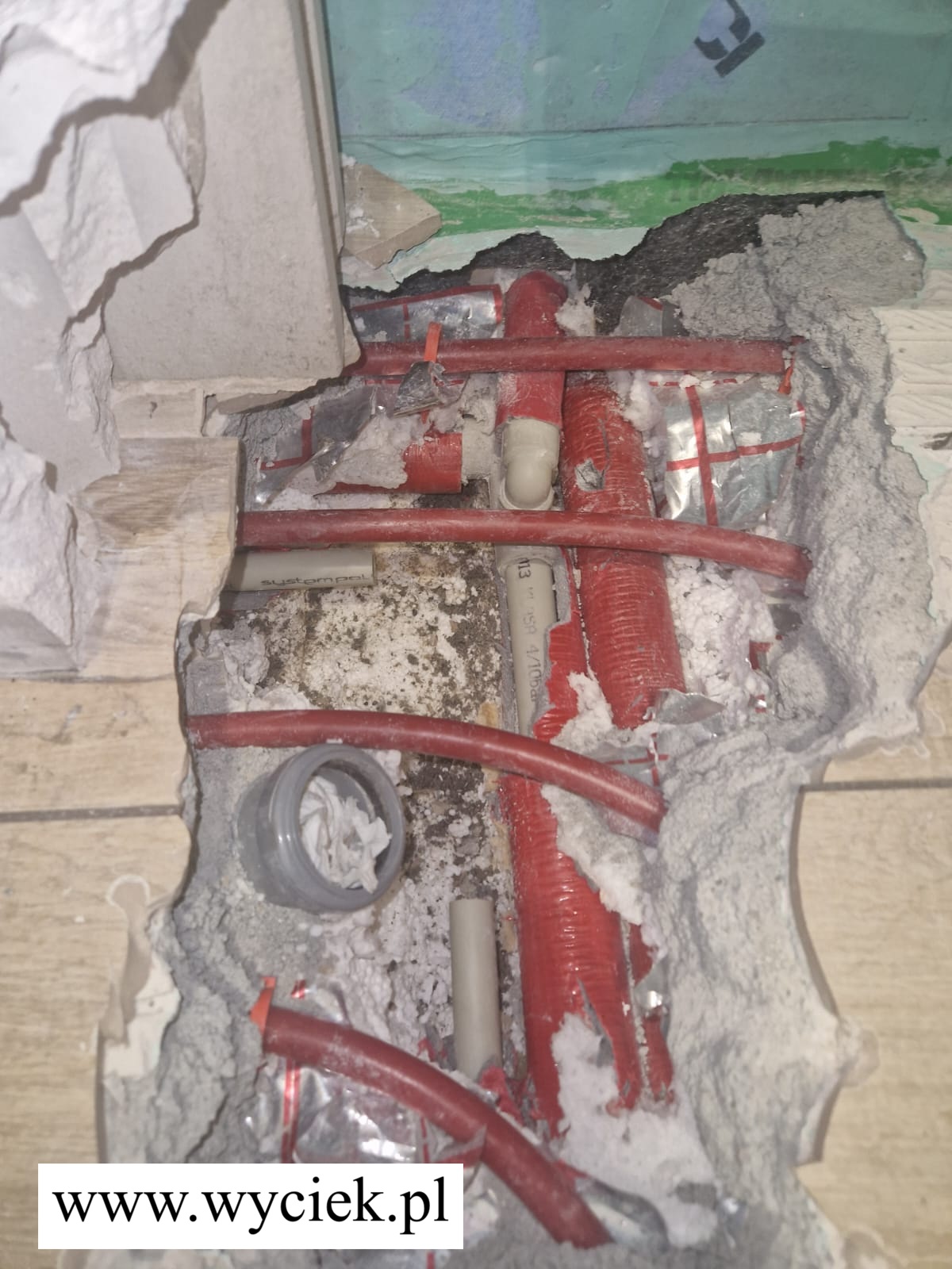 Uszkodzona rura PEX w instalacji podłogowej – widoczne miejsce wycieku wody po odkuciu posadzki