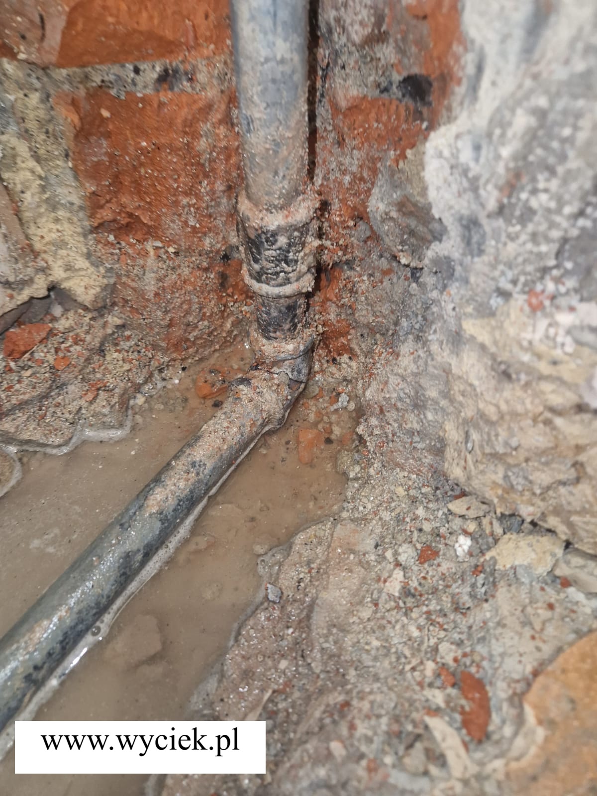 Uszkodzona rura zimnej wody jako przyczyna zalania sufitu w kuchni i zawilgocenia mieszkania.